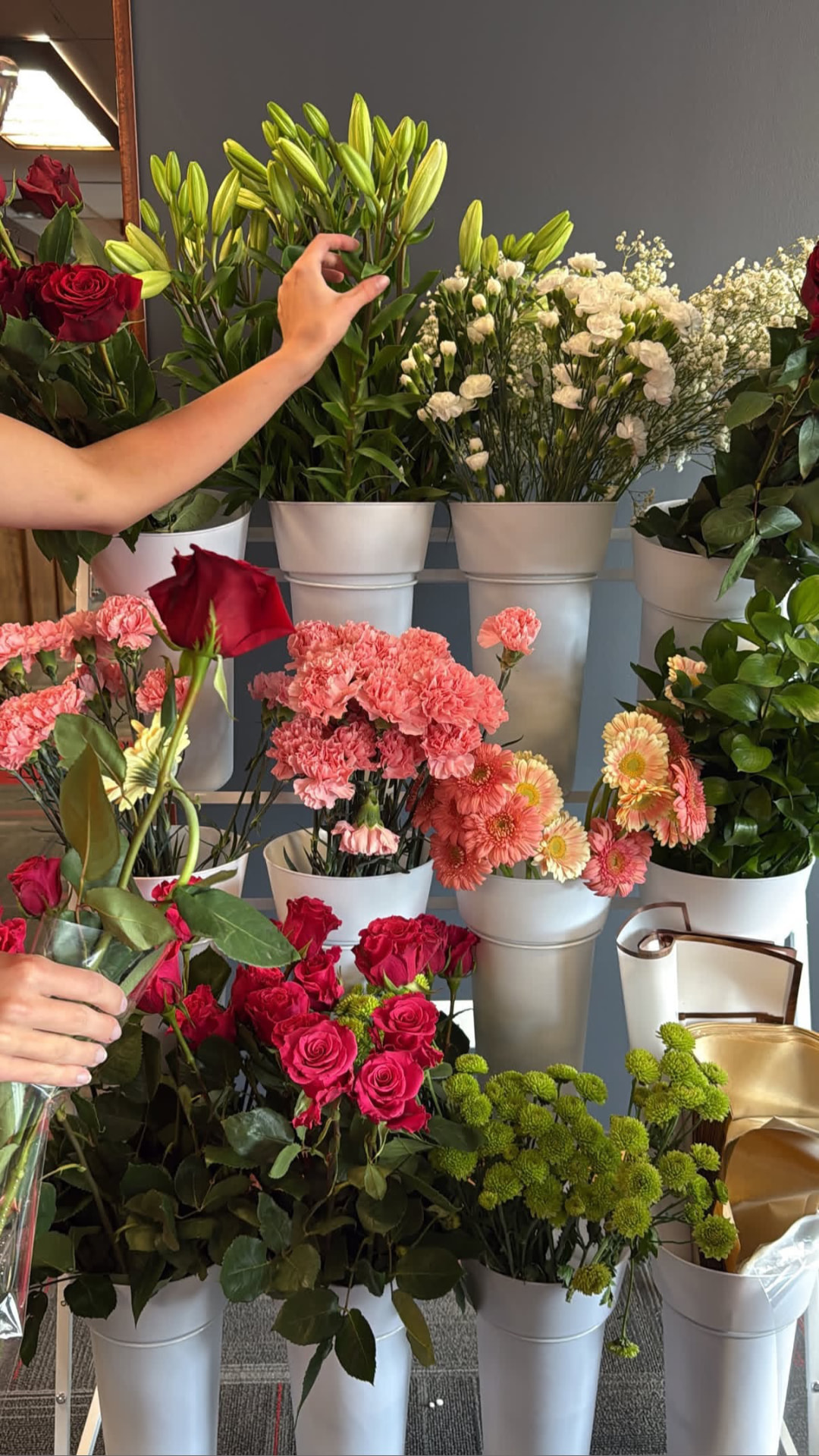 Fresh florals — roses, carnations, gerbera daisies and lilies — being arranged for the event